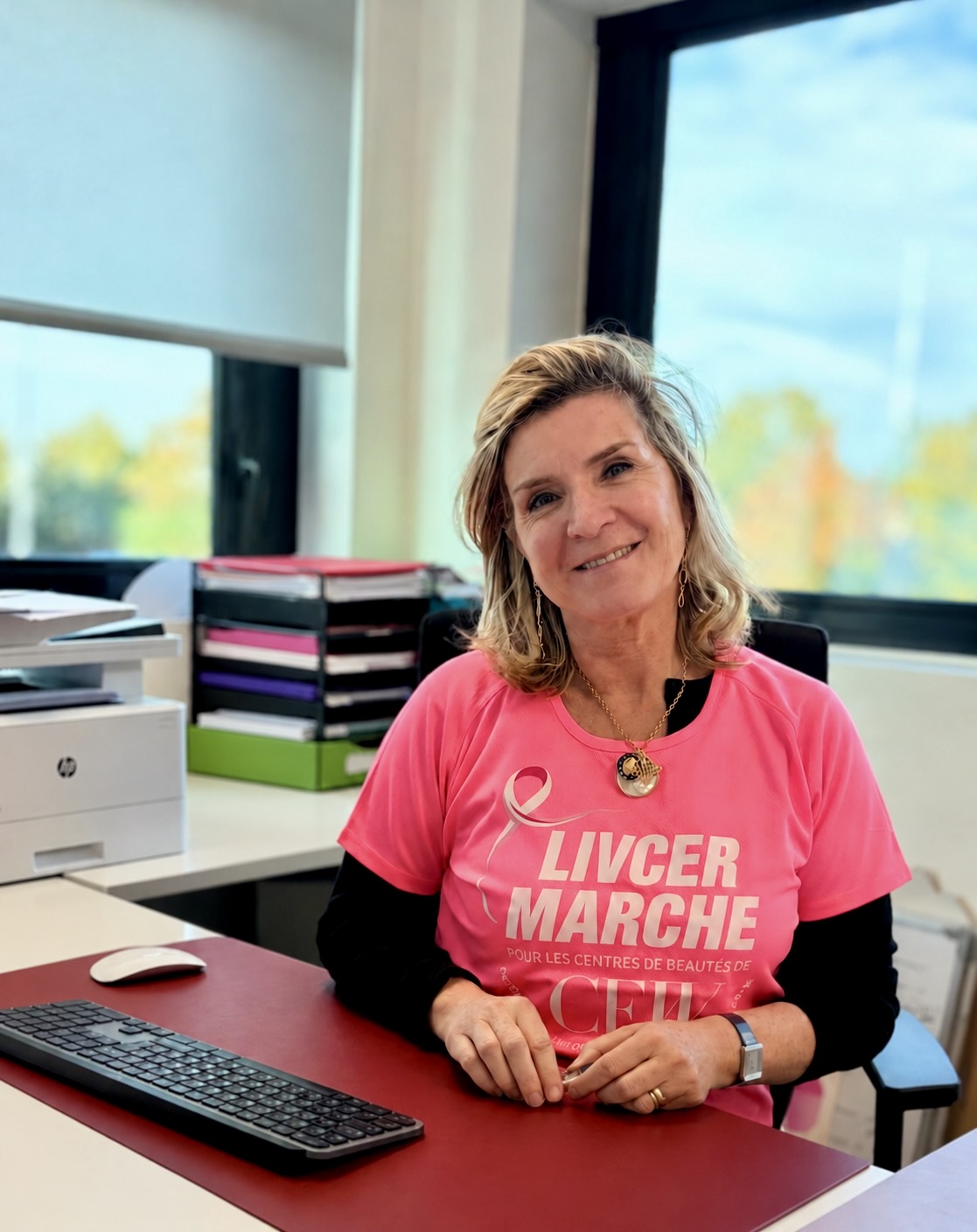 Une collaboratrice LIVCER en t-shirt rose à son bureau.